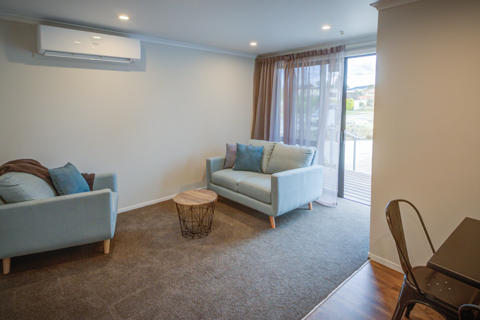 Lounge room of Dusky Motels one-bedroom units with powder blue modern lounge suites