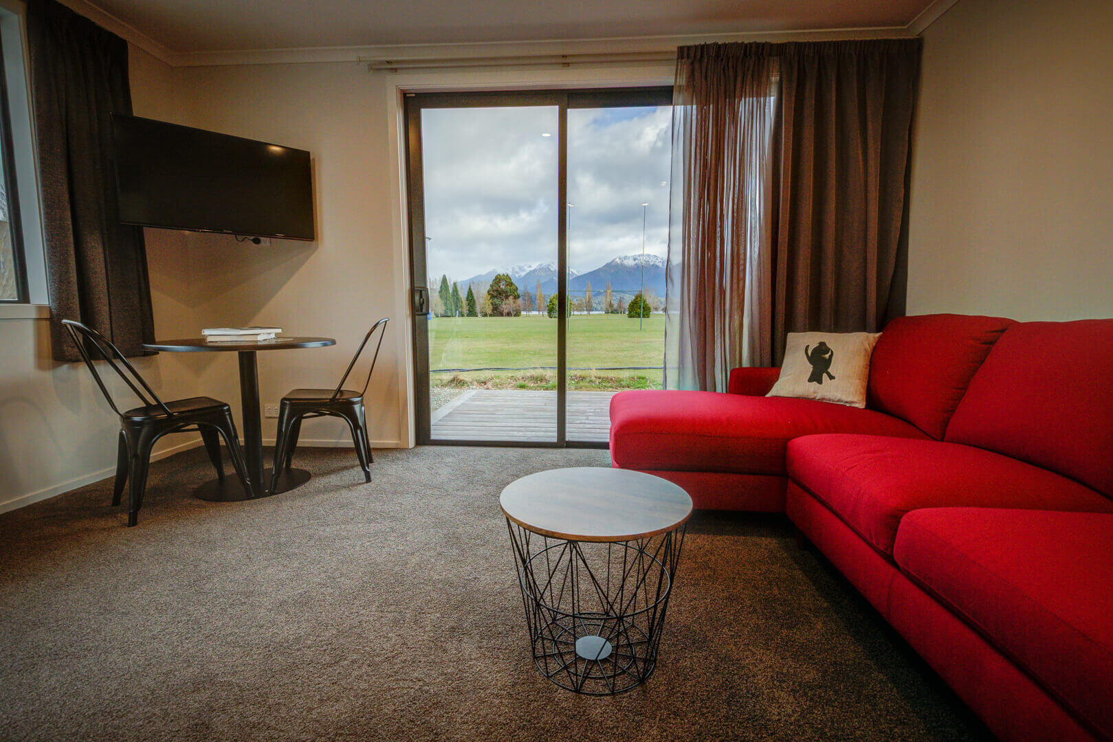 View from the red lounge suite of Dusky Motels Superior Unit out towards parkland and mountains.